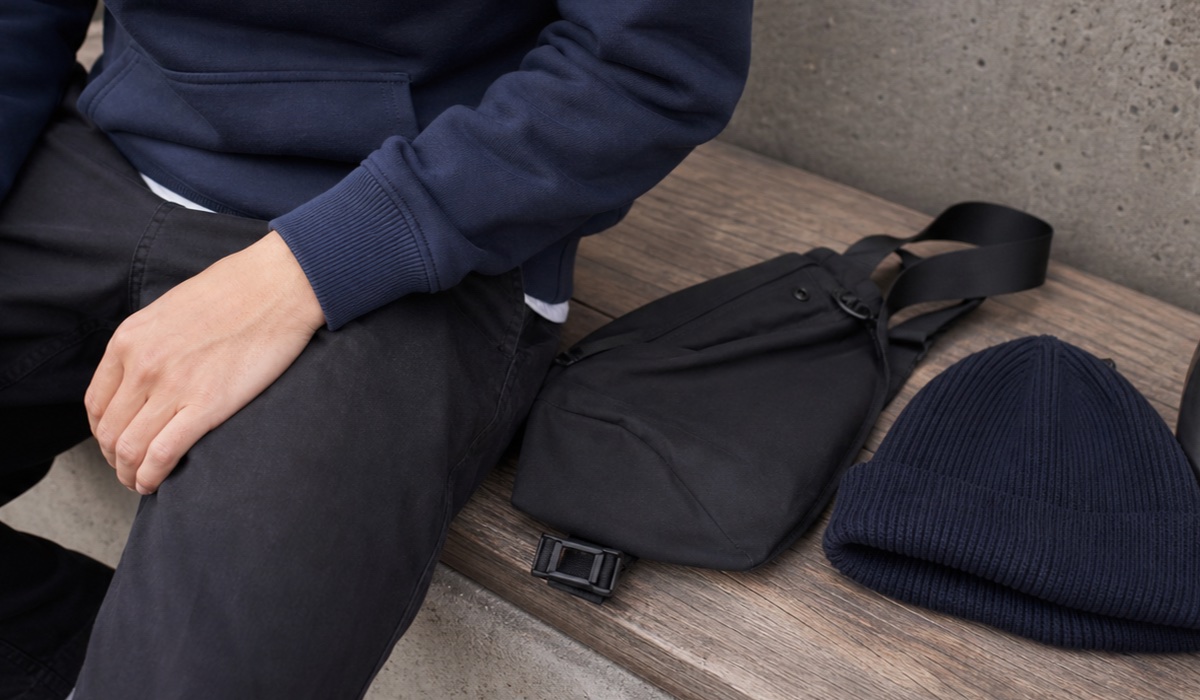 Details eines Streetwear-Looks mit Hoodie, Sneakers und Schultertasche