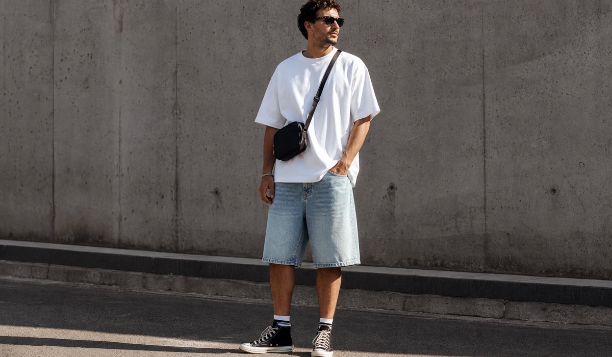 Lockere Jeansshorts mit einem weißen Oversize-T-Shirt und Sneakers