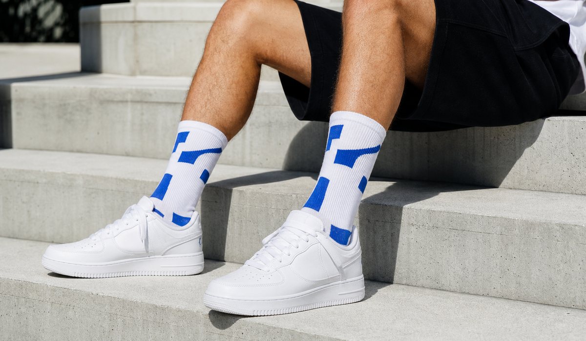 Hohe Socken mit grafischem Akzent und weiße Sneakers
