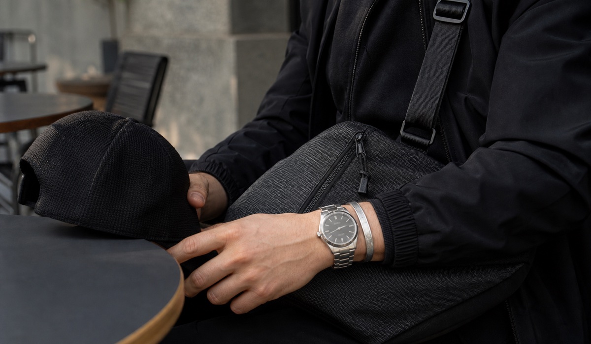 Silver watch and black bag as total black outfit accents