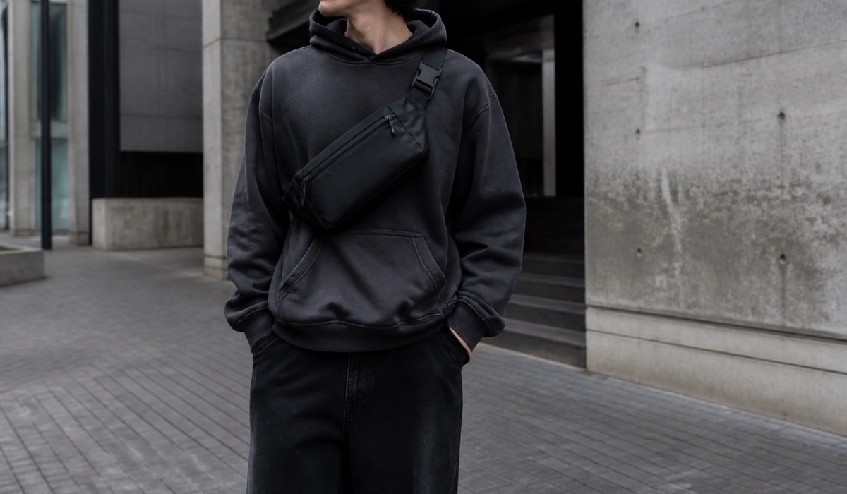 Чорна компактна сумка через плече в повсякденному streetwear-образі